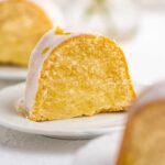 Small lemon cream cheese pound cake slice on a small dessert plate on white background | © Beyond the Butter®