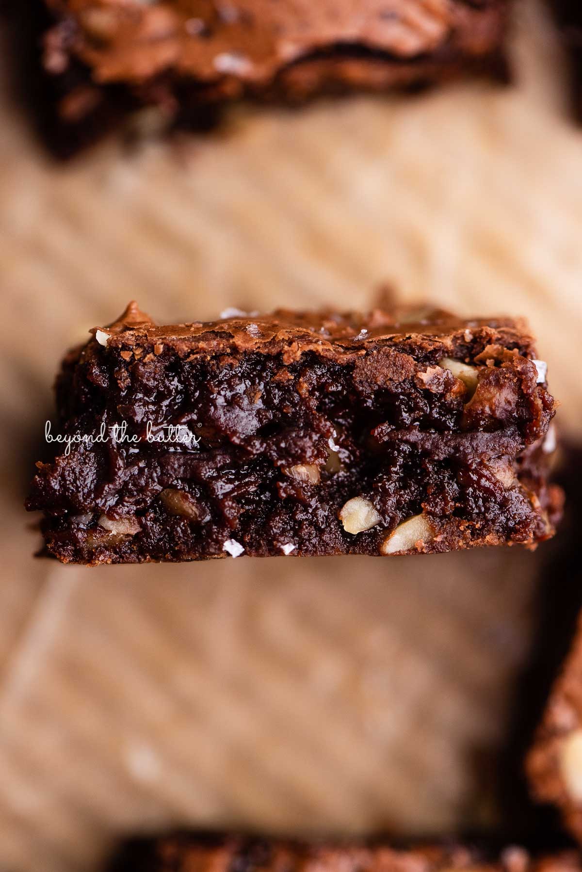 Fudgy better-than-box-mix brownies on a parchment paper lined baking sheet | © Beyond the Butter®