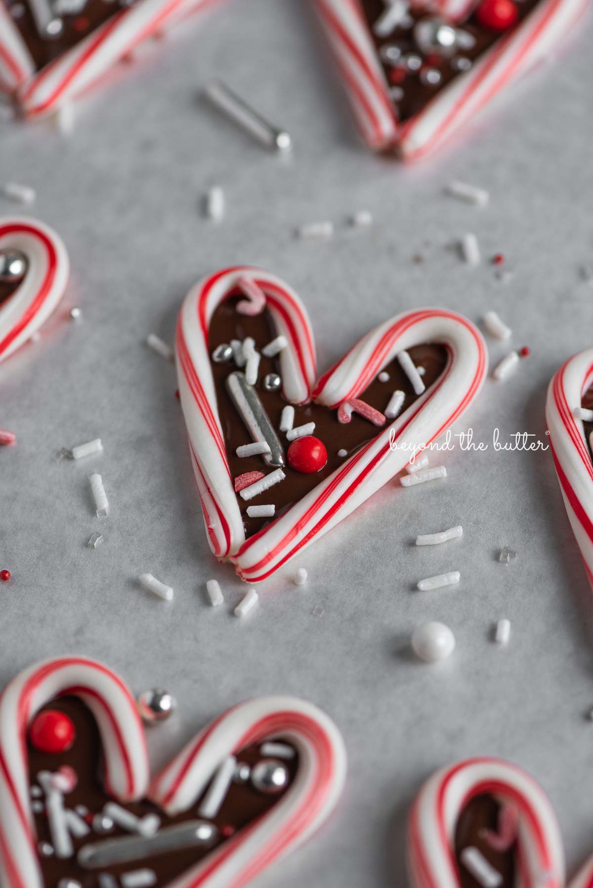 Candy cane hearts on parchment paper | © Beyond the Butter®