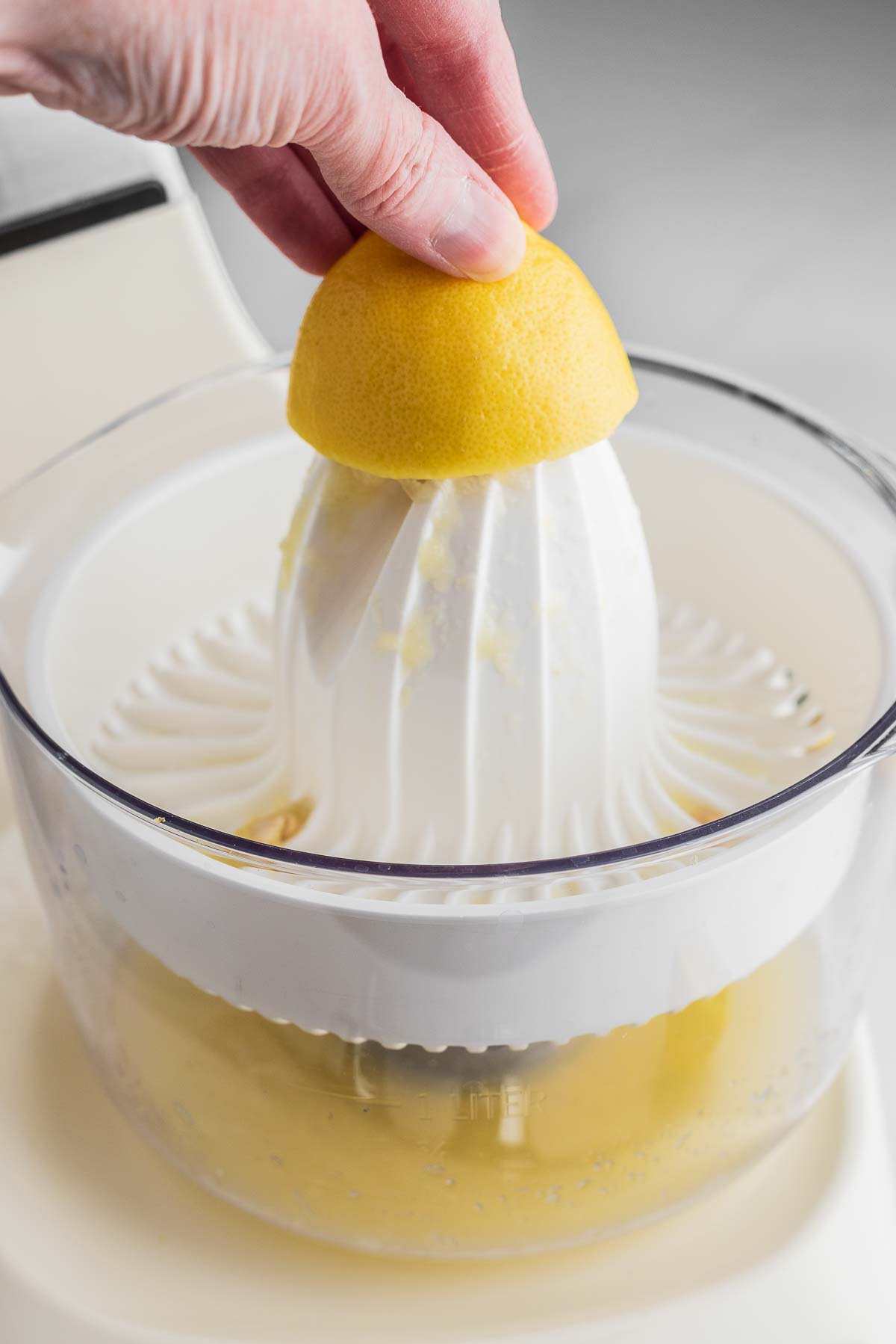 Juicing lemons using a creme light colored ankarsrum assistent original mixer and citrus press attachment.