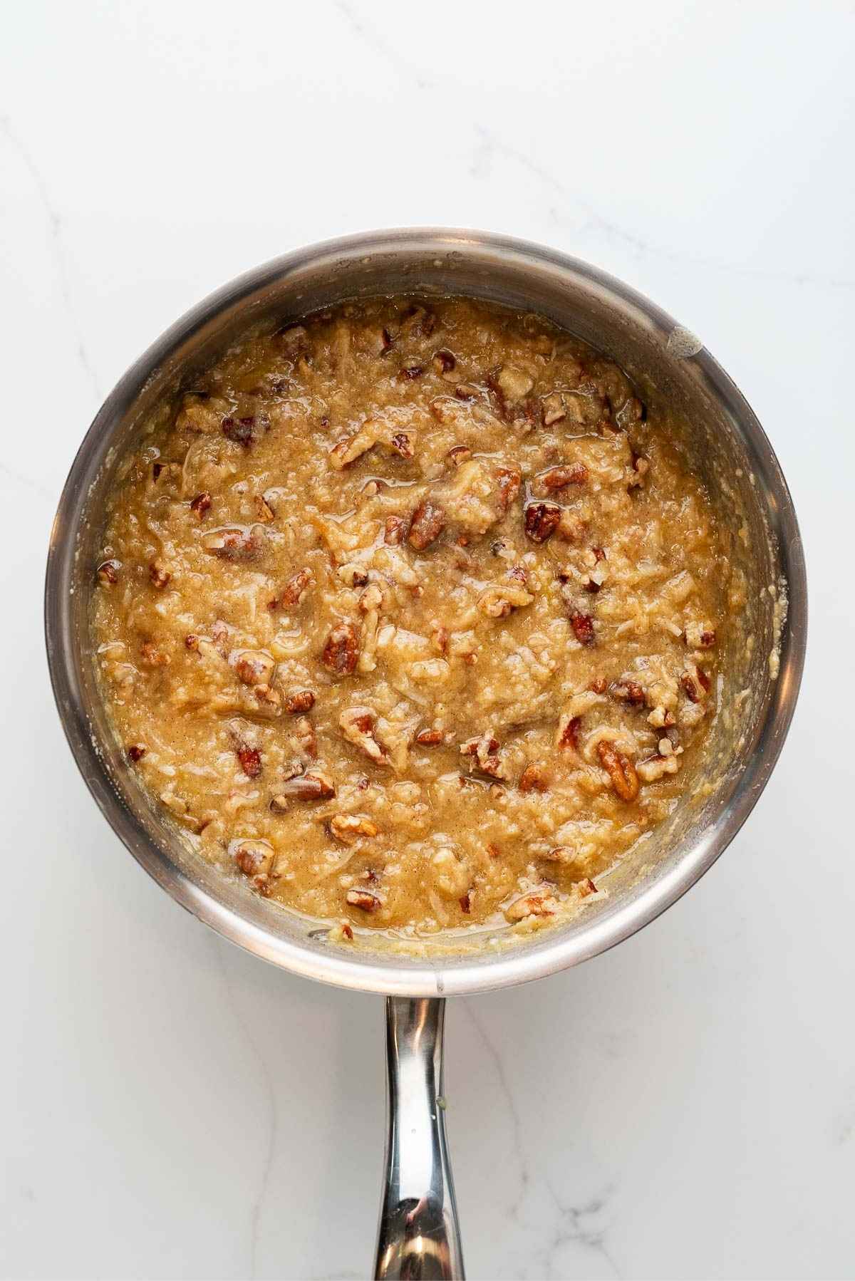Toasted unsweetened coconut flakes and toasted, chopped pecans added to the coconut pecan frosting mixture.